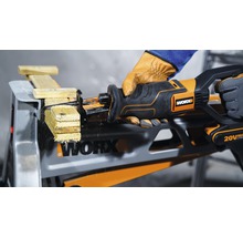 Batteridriven tigersåg som sågar trä på ett arbetsbord, manövrerad av en person med handskar, Worx logotyp synlig.