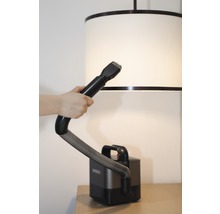 Dammsugare med borstfäste används på en lampskärm