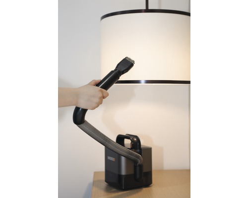 Dammsugare med borstfäste används på en lampskärm