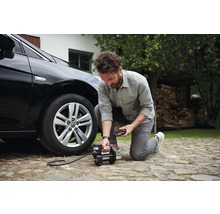Man pumpar upp ett bildäck med en batteridriven kompressor