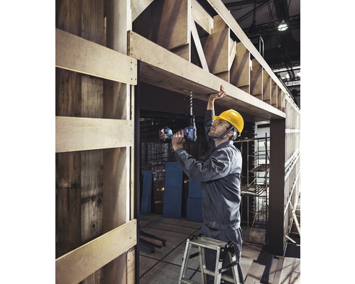 En hantverkare borrar ett hål i en träram med en sladdlös borr.