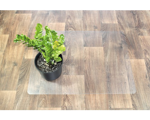 Golvskyddsmatta av plast under en krukväxt på trägolv