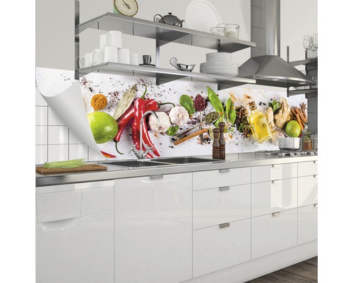 Stänkskydd med kryddmotiv bakom en diskho i ett kök