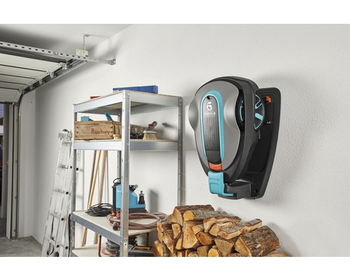 Scen från ett garage med en Gardena robotgräsklippare på väggen, en hylla och trä