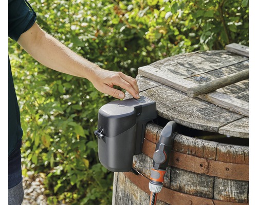 Bevattningsautomat på ett regnvattensfat med slanganslutning och manövrering med en hand.