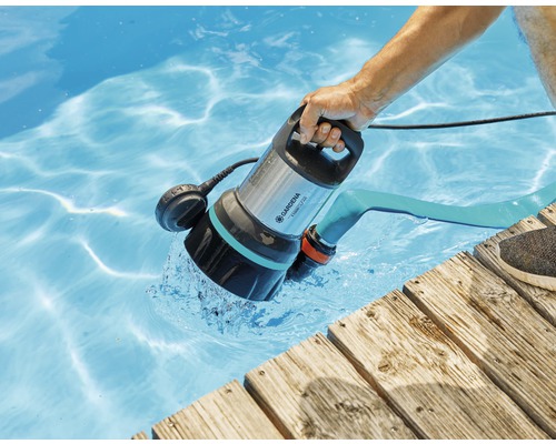 En person använder en Gardena dränkbar smutsvattenpump 7000/D för att tömma en pool.
