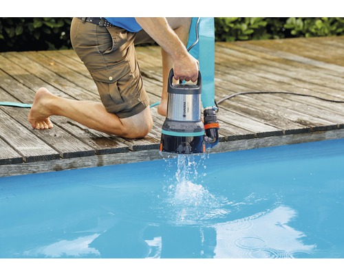 Man tömmer vatten från en pool med en Gardena dränkbar pump för smutsvatten.
