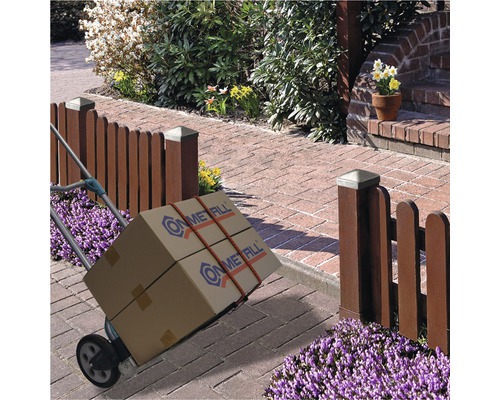 Säckkärra med två paket framför ett trädgårdsstaket