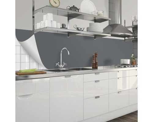 Grått stänkskydd bakom diskbänken i ett kök