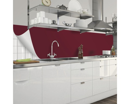 Köksscen med röd köksbänk, diskho och vita skåp.