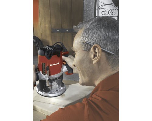 En man använder en handöverfräs från Einhell för träbearbetning.