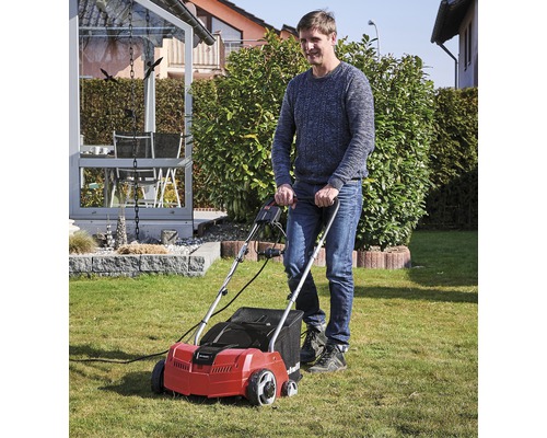 Man använder en gräsmattluftare i trädgården.