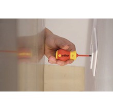 En man skruvar fast ett uttag med en Wiha skruvmejsel.