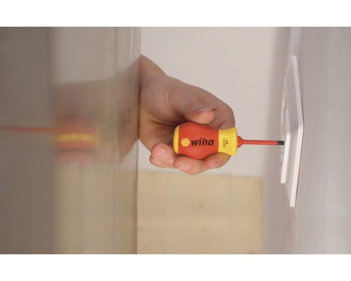 En man skruvar fast ett uttag med en Wiha skruvmejsel.