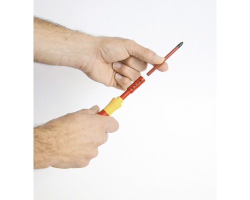 Hand håller skruvmejsel med utbytbar bits