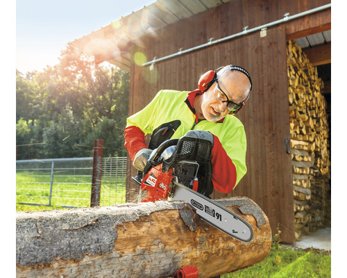 Man sågar ved med en AL-KO motorsåg utomhus.