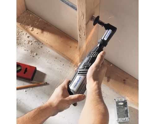 En person använder ett Dremel multiverktyg för att skära trä.