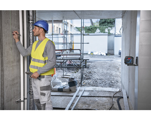 Hantverkare med laservattenpass på en byggarbetsplats