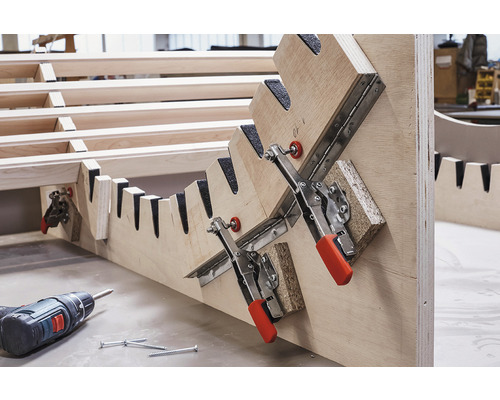 Träkonstruktion med spännanordning, batteridriven skruvdragare och skruvar.