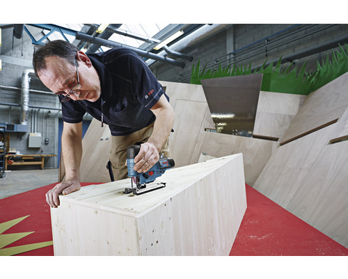 Man sågar en träbit med en sticksåg