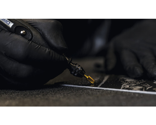 Närbild av en person som utför sliparbete med en Dremel