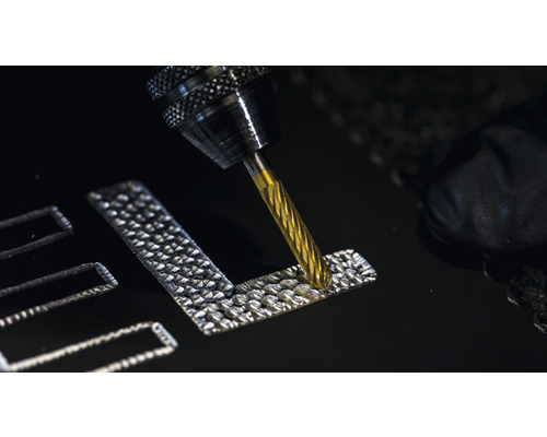 En fräs graverar en design i ett material.