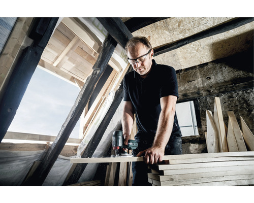 Man som arbetar med en sticksåg på en vind. Träbearbetningsprojekt.