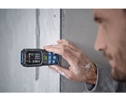 En person använder en Bosch laseravståndsmätare för mätning.