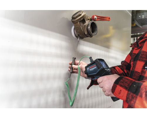 En person använder en Bosch värmekamera för att mäta temperaturen på en ventil.