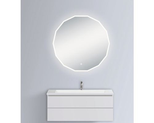 Badrum med belyst spegel i ovanlig form och underskåp med handfat