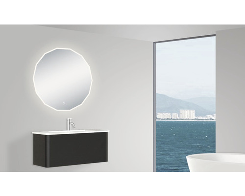 Modernt badrum med spegel, tvättställ och fönster med havsutsikt.