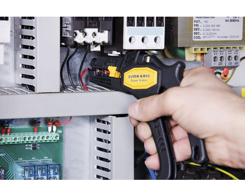 En person använder en Jokari Super 4 Plus avisoleringstång på ett elskåp.