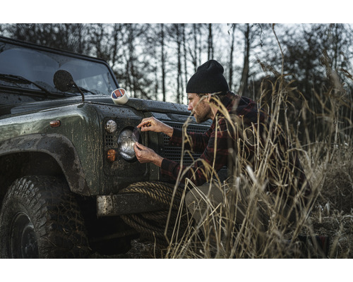 Man applicerar stenskottsskyddsfilm på strålkastare