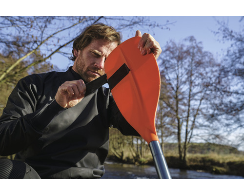 Man fäster paddel vid kajak torrdräkt för utomhusvattensporter