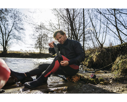 Man sätter på sig neoprenstrumpor vid vattnet