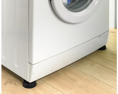 Tvättmaskin med vibrationsdämpande fötter på trägolv