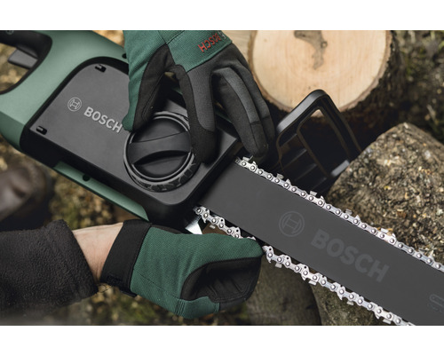Drift av en Bosch motorsåg med skyddshandskar.