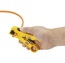 Hand som hanterar en kabelavisolerare med kabel