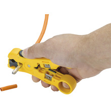 En hand håller en gul kabelstrippare som strippar en kabel.