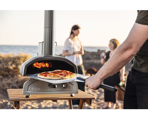 Ooni pizzaugn med pizza på ett bord utomhus