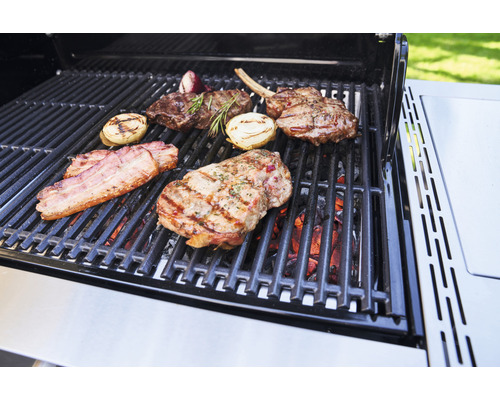 Grill med biffar, lök och bacon på gallret