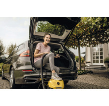 Kvinna använder en Kärcher dammsugare för att rengöra sin bil