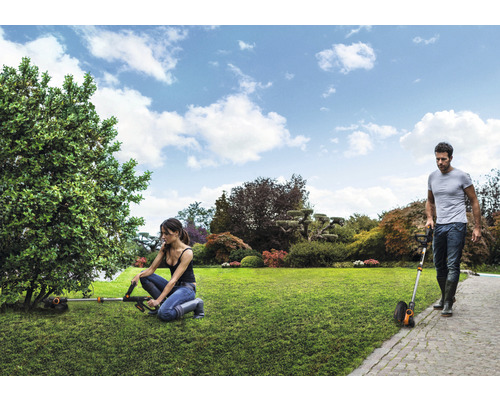 Trädgårdsscen med grästrimmers som arbetar i trädgården.