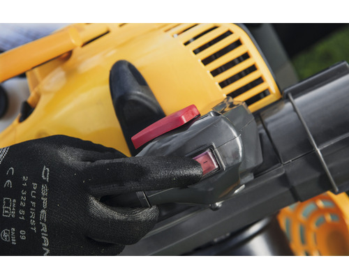 Närbild av en gul lövsug med en hand på strömbrytaren