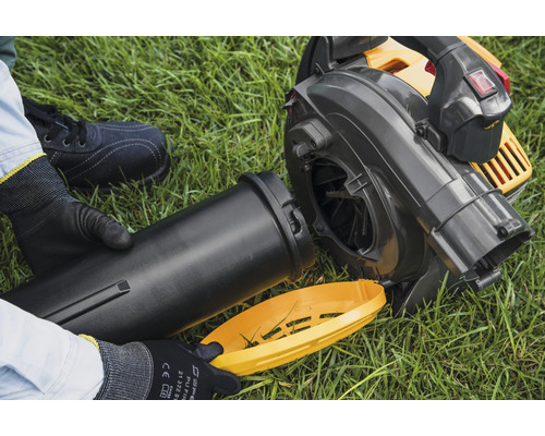 Lövblåsare med monterade tillbehör på gräs