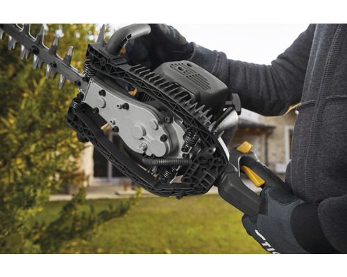 En person använder en häcksax för trädgårdsarbete.