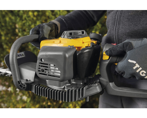 Person håller en gul och grå häcksax