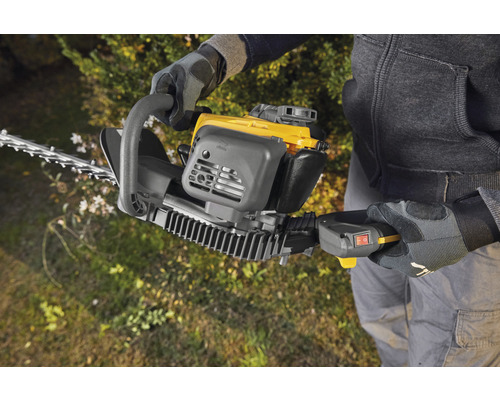 Person använder en häcksax för att trimma häckar