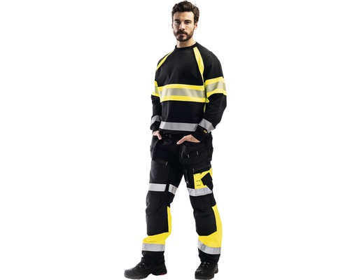 Man i svarta och gula varselbyxor och varselfleece