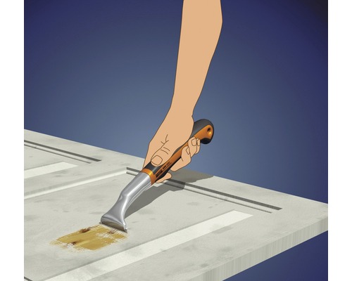 Hand med färgskrapa tar bort färg från en dörr